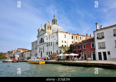 VENEDIG, ITALIEN - 24. SEPTEMBER 2014: Giudecca Insel, Kanal und Boot bei Sonnenuntergang. Venedig und die venezianische Lagune sind auf der UNESCO-Liste des Weltkulturerbes Stockfoto