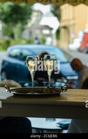 Zwei Gläser kalten Weißweins in einem Tablett auf einer Bar Arbeitsplatte mit selektivem Fokus und Bokeh Stockfoto