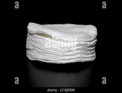 Weiße Baumwollpads Make-up Entferner. Stapel von Knospen/Tupfern isoliert auf schwarzem Hintergrund Stockfoto