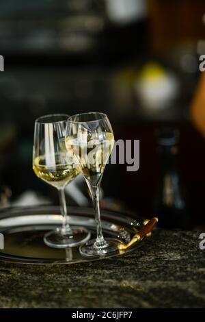 Zwei Gläser kalten Weißweins in einem Tablett auf einer Bar Arbeitsplatte mit selektivem Fokus und Bokeh Stockfoto