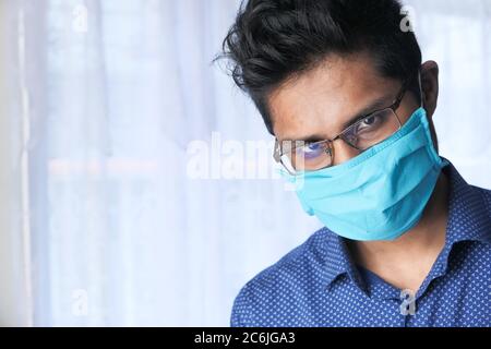 Junger Mann mit Schutzmaske Blick auf Kamera Stockfoto