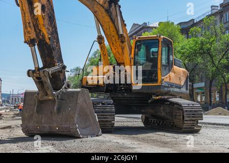 Bagger und sein Eimer auf der Baustelle einer neuen Straße Stockfoto