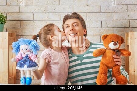 Glückliche liebevolle Familie. Vater und seine Tochter im Kinderzimmer. Lustige Papa und schönes Kind Spaß und spielen Leistung im Puppentheater drinnen Stockfoto