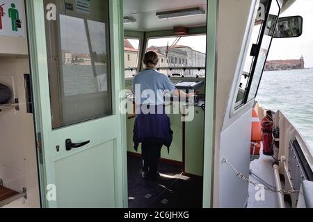 VENEDIG, ITALIEN - 24. SEPTEMBER 2014: Vaporetto-Fahrer bei der Arbeit. Vaporetto, auch bekannt als Wasserbus, ist der Haupttransport in Venedig Stockfoto