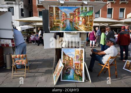 VENEDIG, ITALIEN - SEP 24, 2014: Unbekannter Künstler verkauft Gemälde am Wasser in Venedig. Touristen aus aller Welt genießen die historische Stadt Ven Stockfoto