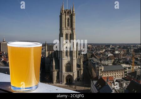 Ein Glas helles belgisches Bier vor dem Blick auf die große Kathedrale in Gent, Belgien Stockfoto