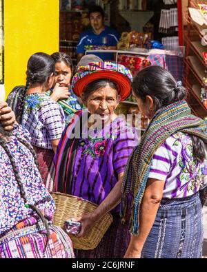 Guatemala, Solola Department, Santiago Atitlan, ältere Maya-Frauen in traditioneller Kleidung auf dem wöchentlichen offenen Markt. Eine Frau trägt die für diese Stadt charakteristische tocoyal Kopffolie. Es wurde einmal häufig von verheirateten Frauen getragen, ist aber jetzt zu teuer für die meisten zu leisten. Stockfoto