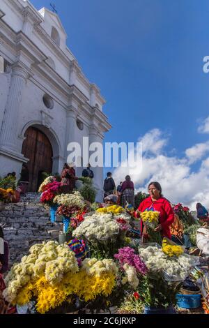 Die Verkäufer verkaufen Blumen auf den Stufen der Kirche Santo Tomas in Chichicastenango, Guatemala. Die Kirche wurde um 1545 auf den Stufen einer Maya-Pyramide gebaut. Stockfoto