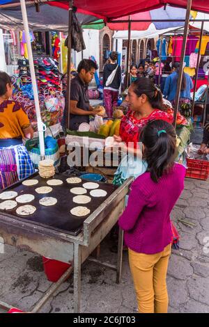 Guatemala, El Quiche Department, Chichicastenango, EINE Quiche Mayanerin, stellt Tortillas in einem Imbissstand auf dem indischen Markt. Stockfoto