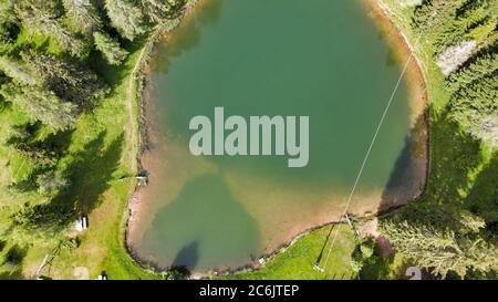 Alpin See im Sommer umgeben von schönen Wald, über Kopf nach unten Luftaufnahme. Stockfoto