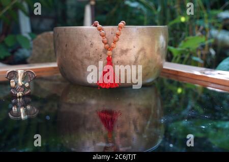 Tibetische Klangschale Nahaufnahme mit schönen woodon Mala und Ganesha Gottheit für Klangheilung Stockfoto