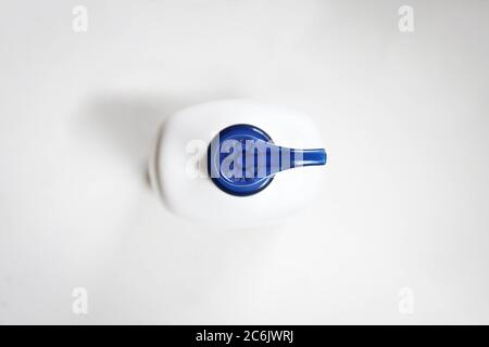 Blauer Deckel der Sprühflasche auf Weiß. Oberseite des Behälters der Kosmetikpumpe. Öffnen/Stopp Stockfoto