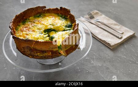 Hausgemachte französische Torte oder Quiche lorraine Lachs Pie auf einer Glasplatte, Gabel und Messer serviert Stockfoto