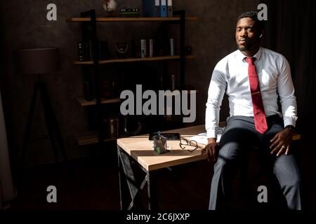 Porträt eines schönen afrikanischen Geschäftsmann mit roter Krawatte und schwarzer Brille im Büro Stockfoto