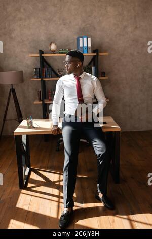 Porträt eines schönen afrikanischen Geschäftsmann mit roter Krawatte und schwarzer Brille im Büro Stockfoto