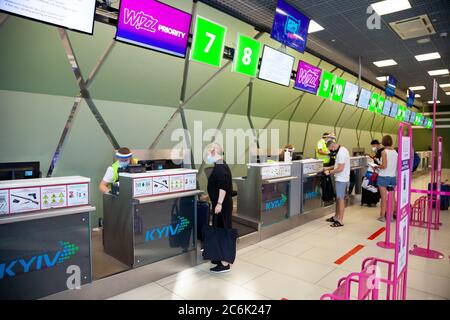 Kiew, Ukraine - 26. Juni 2020: Maskierte Menschen auf dem Flughafen Kiew. Öffentlicher Ort während der Quarantänezeit.Flughafenmitarbeiter in medizinischen Masken und Stockfoto