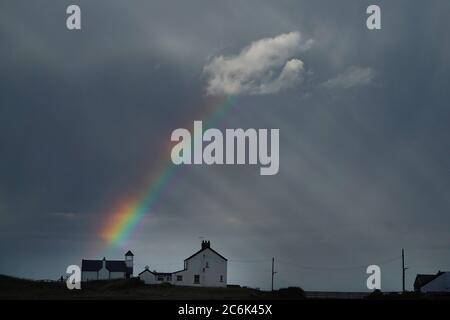 Am Freitag erscheint ein atemberaubender Regenbogen im Hafen von Seaton Sluice in Northumberland, während schwere Regenschauer die Region fegen. Stockfoto