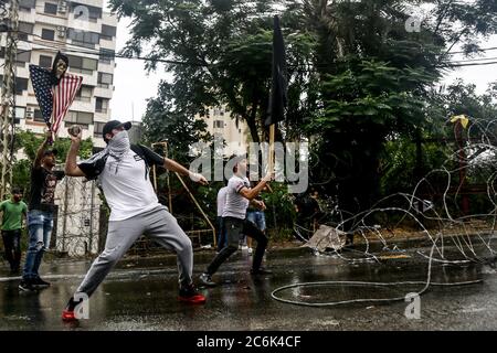 Awkar, Libanon. Juli 2020. Demonstranten schleudern Steine auf die Anti-Riot-Polizei während der Zusammenstöße bei einer Demonstration gegen die von den Demonstranten so genannte Einmischung Washingtons in libanesische Angelegenheiten in der Nähe der US-Botschaft in Awkar nördlich von Beirut. Dutzende Anhänger der vom Iran unterstützten Hisbollah-Bewegung und ihrer Verbündeten im Libanon veranstalteten am Freitag einen Anti-US-Protest in der Nähe der US-Botschaft. Quelle: Marwan Naamani/dpa/Alamy Live News Stockfoto