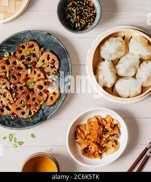 Asiatische Vorspeisen wie Lotuswurzel, gedünstete Gemüseknödel und gebratene Karotten mit Dipping-Sauce umrühren Stockfoto