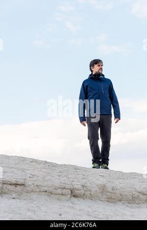 Von unten erwachsener Tourist Mann auf der Spitze des Hügels in Kappadokien, Türkei. Stockfoto