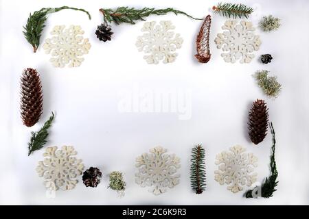 Weihnachtsrahmen aus einer Mischung aus Tannenzapfen, Fichtenzapfen, Fake, Schneeflocken, Flechten, Wacholder und Fichtenzweige. Silbernes Girland von winzigen silbernen Kugeln. Kopieren Stockfoto