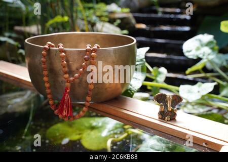 Tibetische Klangschale Nahaufnahme mit schönen woodon Mala und Ganesha Gottheit für Klangheilung Stockfoto