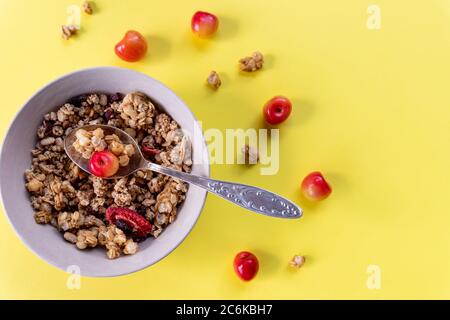 Leckeres und gesundes Vollkornmüsli-Frühstück, mit vielen trockenen Früchten, Nüssen, Körnern und einem frischen Kirschen.Haferflocken und frischen Beeren.Essen gemacht Stockfoto