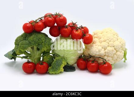 Kopf von Kohl, Blütenstände von Brokkoli und Blumenkohl und rot reifen Tomaten auf einem hellen Hintergrund. Naturprodukt. Natürlicher Farbton. Nahaufnahme. Stockfoto