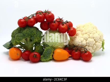 Kopf von Kohl, Blütenstände von Brokkoli und Blumenkohl und rot und gelb reifen Tomaten auf einem hellen Hintergrund. Naturprodukt. Natürlicher Farbton. Stockfoto