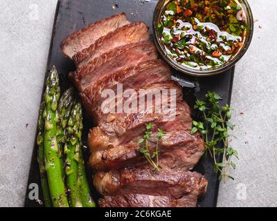 Saftiges, gegrilltes, geschnittenes Rindersteak, mit gebratenem Spargel, Nahaufnahme, Sauce Stockfoto