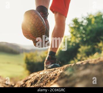 Trekking Boot Sohle Nahaufnahme Bild Reisende Füße in Trekking Stiefel auf Berg schmutzigen Weg im Sommer. Stockfoto