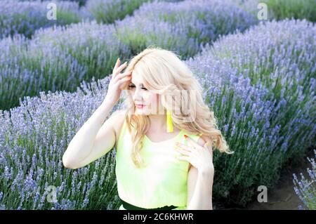 Eine Frau geht durch ein blühendes Lavendelfeld. Blumen und Frauen Stockfoto