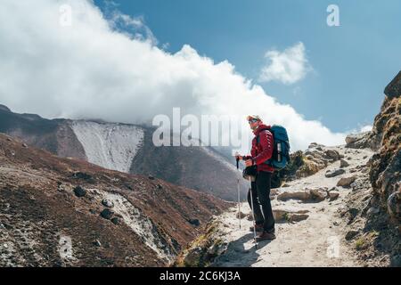 Wanderer Mann Silhouette auf Wolken Hintergrund stehend auf Pfad über das Imja Khola Tal und genießen Sie die Aussicht auf die Berge während eines Everest Base Camp tr Stockfoto