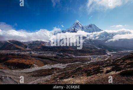 Weitwinkel Blick auf Ama Dablam 6814m Gipfel bedeckt mit Wolken und Tschukhung Dorf 4730m liying auf Imja Khola Flussufer Sagarmatha Nationalpark. Immer Stockfoto
