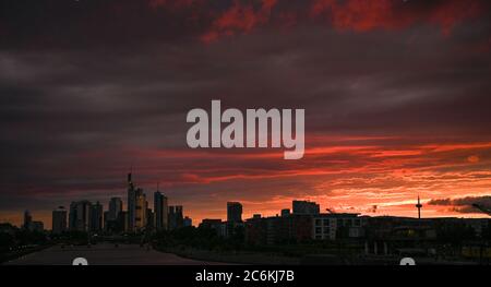 10. Juli 2020, Hessen, Frankfurt/Main: Die Sonne geht abends hinter der Skyline der Bankenstadt unter. Foto: Arne Dedert/dpa Stockfoto