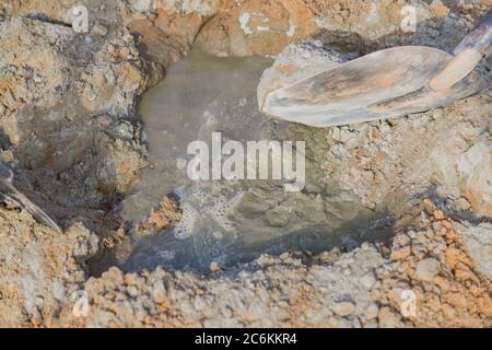 Wasser auf die Mischung aus Sand und Zement einstreügeln. Zement bei der Herstellung von Zement, Stockfoto