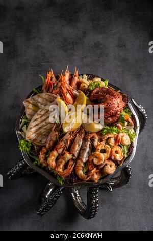 Gemischte Meeresfrüchte enthalten Blaukrabben, Muscheln, große Garnelen, Calamari-Tintenfische und gegrillten Barracuda Fisch Knoblauch mit Zitrone auf Gericht Stockfoto