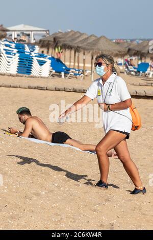 Punta Umbria, Huelva, Spanien - 9. Juli 2020: Die Strandwache der Junta de Andalucia kontrolliert die soziale Distanzierung und den Einsatz von Schutzmasken Stockfoto