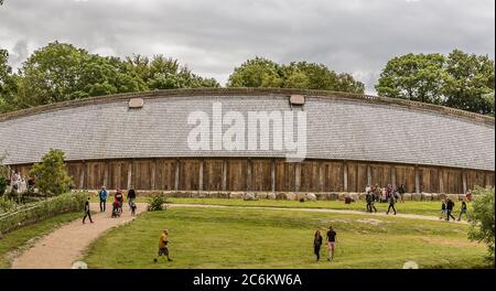 Menschen vor dem Königssaal ein mittelalterliches Langhaus. Rekonstruktion einer Wikingerhalle aus den 700er Jahren in Lejre, Dänemark, 9. Juli 2020 Stockfoto