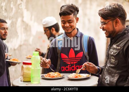 Neu Delhi / Indien - 16. Februar 2020: Junge Studenten essen auf der Straße neben der Universität in Delhi Stockfoto