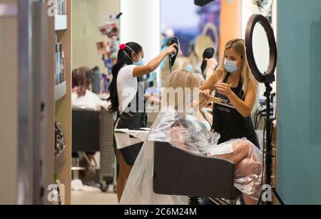 Toronto, Kanada. Juli 2020. Ein Friseur mit Gesichtsmaske schneidet einem Kunden am 10. Juli 2020 in einem Friseursalon im CF Toronto Eaton Centre in Toronto, Kanada, die Haare. Die Wirtschaft fügte 953,000 Arbeitsplätze in Kanada, und die Arbeitslosenquote sank auf 12.3 Prozent im Juni, als Unternehmen wieder nach der Schließung COVID-19, nach Statistik Kanada Freitag. Quelle: Zou Zheng/Xinhua/Alamy Live News Stockfoto