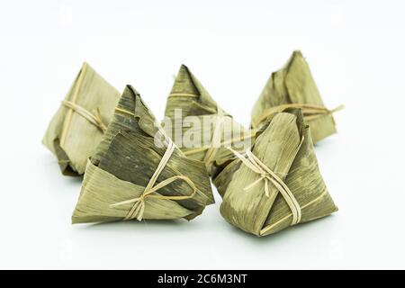 Nahaufnahme des Zongzi, es ist ein traditionelles chinesisches Reisgericht aus klejewem Reis, gefüllt mit verschiedenen Füllungen und in Schilfblätter gewickelt. Stockfoto