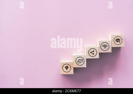 Nahaufnahme von Holzblock Stapeln als Treppe auf Papier rosa Pastell Hintergrund mit Kopierraum. Business Online Icons Konzept. Stockfoto