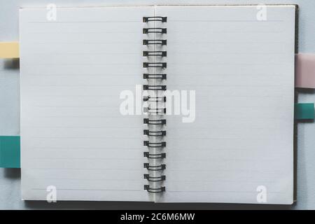 Draufsicht auf leeres Space weißes Notizbuch und Stift mit tropischem Blatt als Rahmenhintergrund. Stockfoto