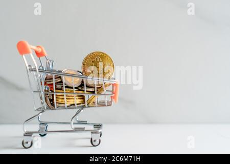 Bitcoin oder Kryptowährung Symbol in Mini-Warenkorb-Modell voller Münzen Geld mit Copyspace weißen Hintergrund. Stockfoto