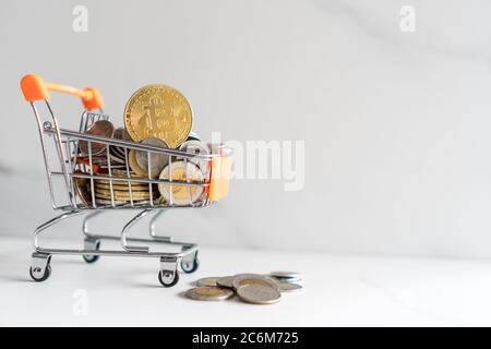 Bitcoin oder Kryptowährung Symbol in Mini-Warenkorb-Modell voller Münzen Geld mit Copyspace weißen Hintergrund. Stockfoto