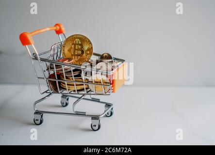 Bitcoin oder Kryptowährung Symbol in Mini-Warenkorb-Modell voller Münzen Geld mit Copyspace weißen Hintergrund. Stockfoto