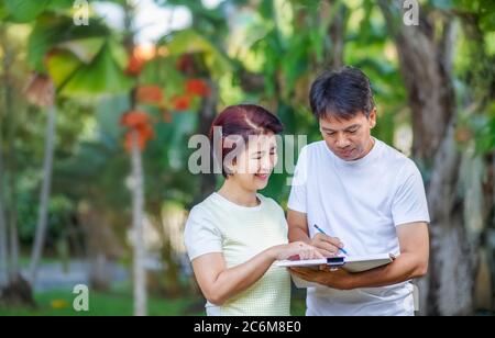 Asiatische Mitte-Alter-Paar reden und Gestaltung Garten Plan zusammen im Hinterhof. Stockfoto