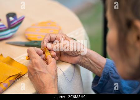 Ältere Frau mit Betreuer in der Nadel Handwerk Ergotherapie für Alzheimer oder Demenz Stockfoto