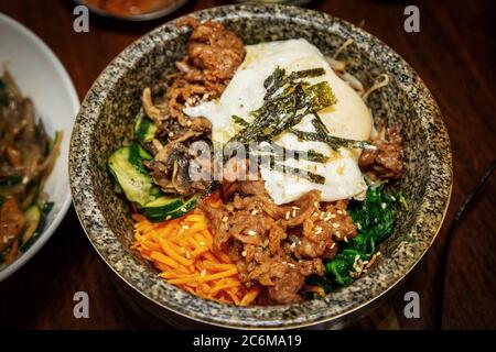 Traditionelle koreanische Hot Stone Bi BIM Bap Reisgericht mit Gemüse, Rindfleisch und Ei gemischt Stockfoto